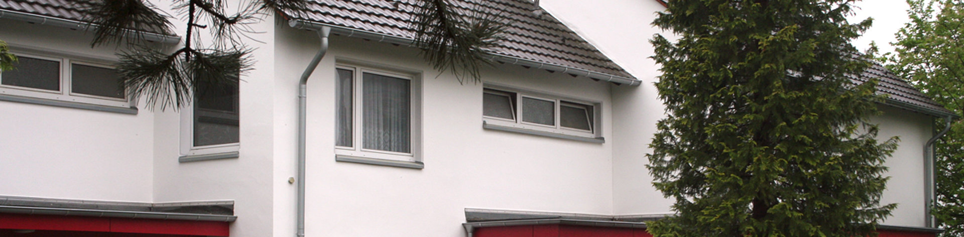 Fassadengestaltung Reihenhauses mit  Trespa Farbe kaminrot